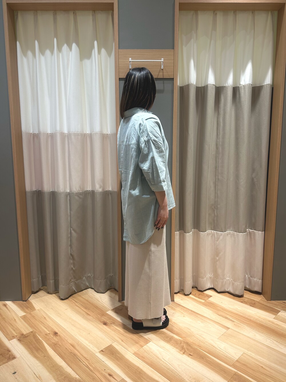 グリーン系のトップス、ベージュ系のスカート、ホワイト系のサンダルを着用したレディースの春コーディネートの4枚目の写真