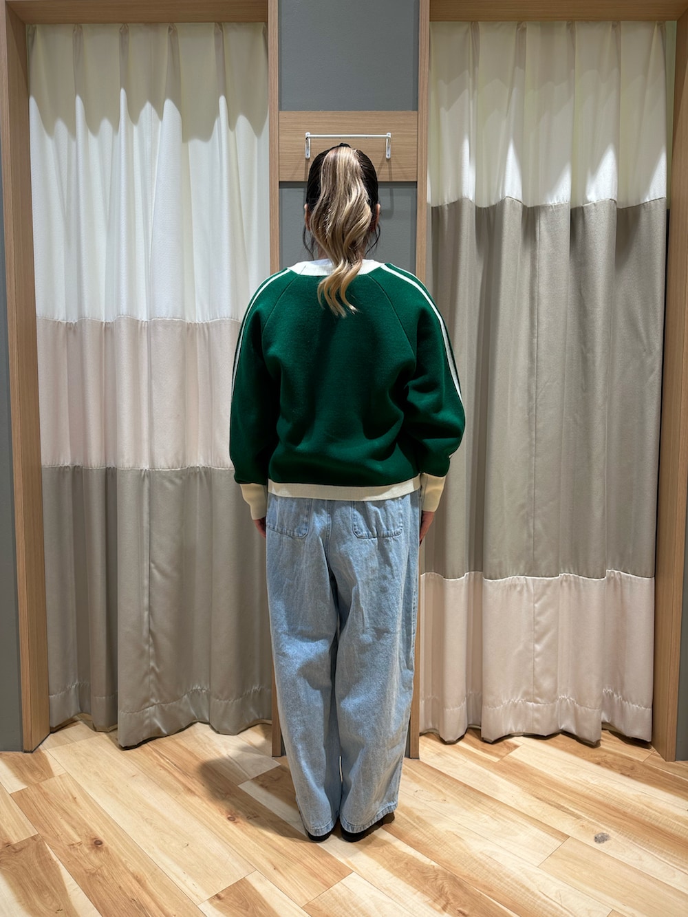 ホワイト系のTシャツ/カットソー、グリーン系のカーディガン/ボレロ、ブルー系のデニムパンツを着用したレディースの冬コーディネートの3枚目の写真