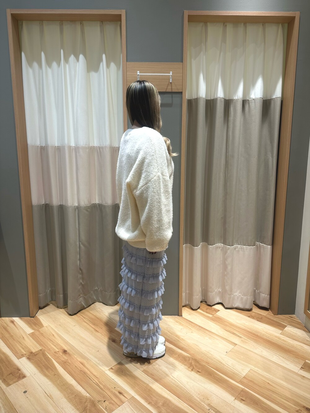 ブラック系のTシャツ/カットソー、ホワイト系のニット/セーター、ブルー系のスカートを着用したレディースの冬コーディネートの4枚目の写真