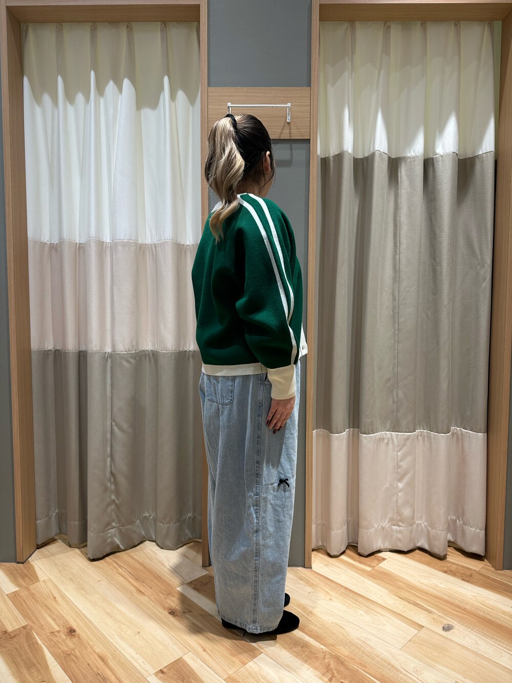 ホワイト系のTシャツ/カットソー、グリーン系のカーディガン/ボレロ、ブルー系のデニムパンツを着用したレディースの冬コーディネートの4枚目の写真