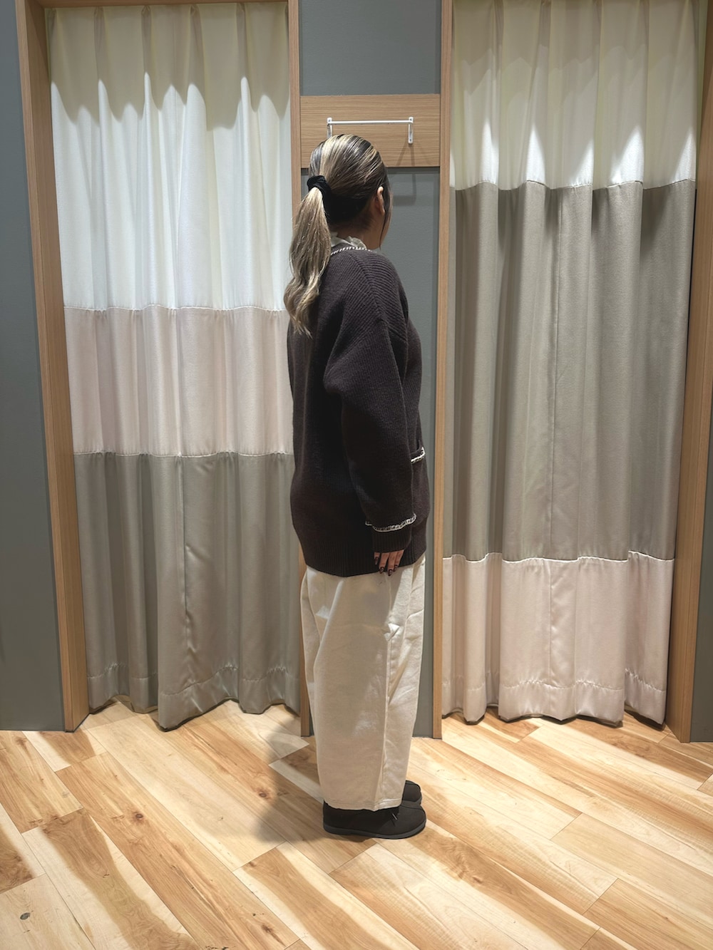 ホワイト系のニット/セーター、ブラウン系のカーディガン/ボレロ、ホワイト系のパンツを着用したレディースの冬コーディネートの4枚目の写真