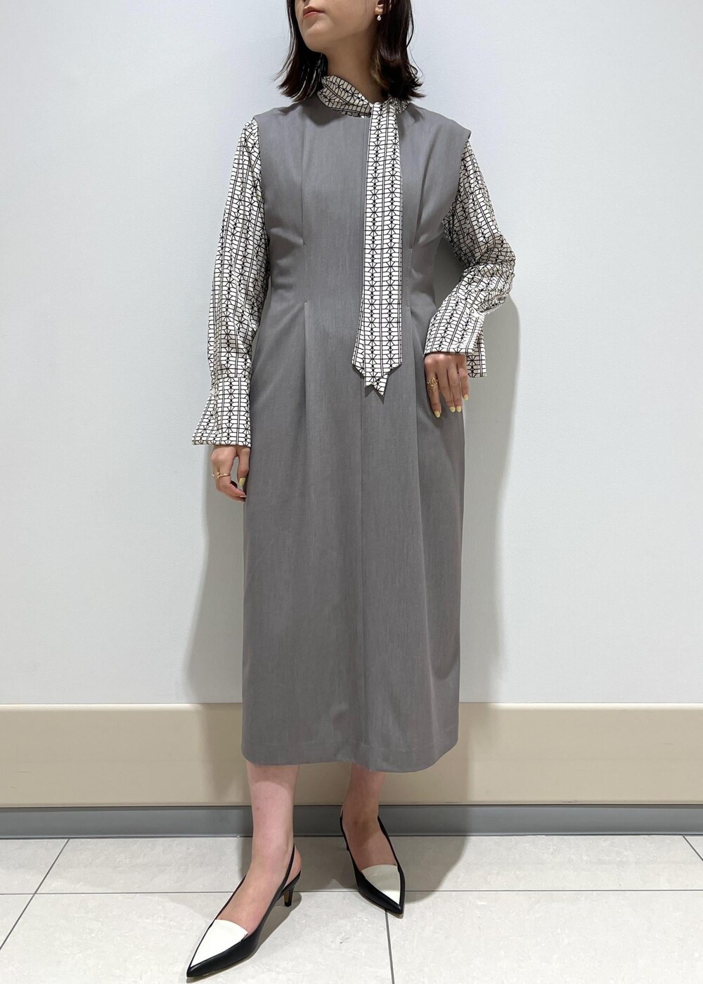 ホワイト系のシャツ/ブラウス、ブルー系のトートバッグ、ブラック系のパンプスを着用したレディースの春コーディネートの6枚目の写真