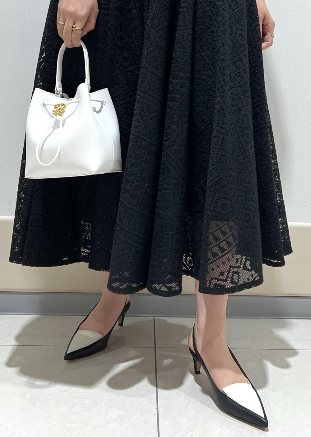 ホワイト系のハンドバッグ、ブラック系のパンプス、ピンク系のシャツ/ブラウスを着用したレディースの春コーディネートの9枚目の写真