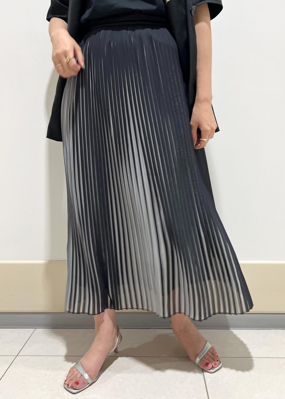 シルバー系のサンダル、グリーン系のショルダーバッグ、ブラック系のスカートを着用したレディースの夏コーディネートの9枚目の写真