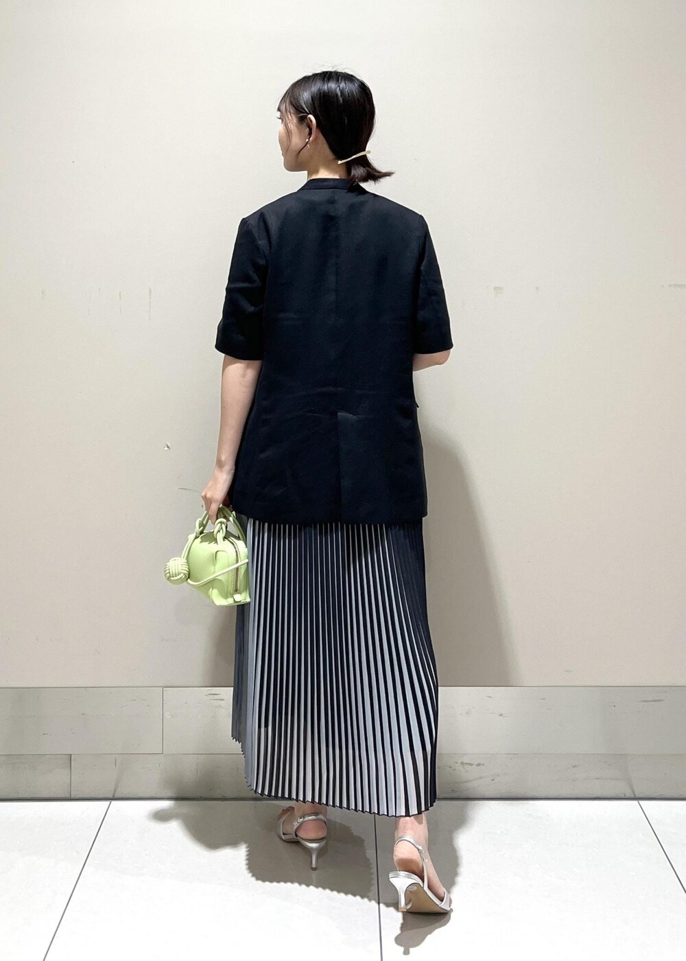 シルバー系のサンダル、グリーン系のショルダーバッグ、ブラック系のスカートを着用したレディースの夏コーディネートの4枚目の写真