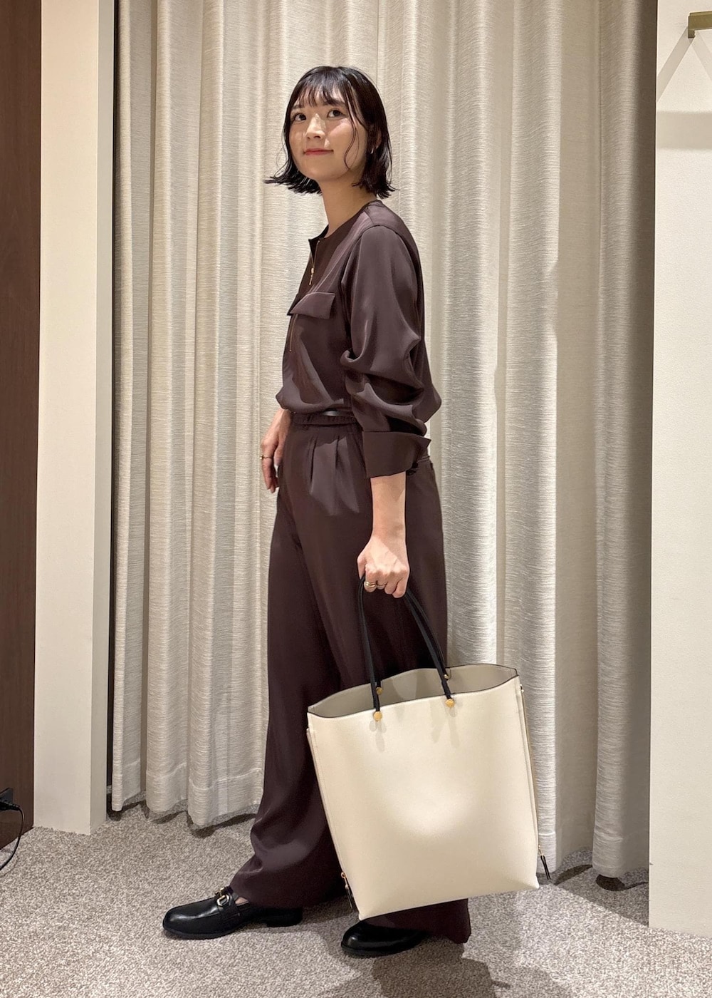 ブラック系のローファー、ホワイト系のトートバッグ、ブラウン系のシャツ/ブラウスを着用したレディースの春コーディネートの3枚目の写真
