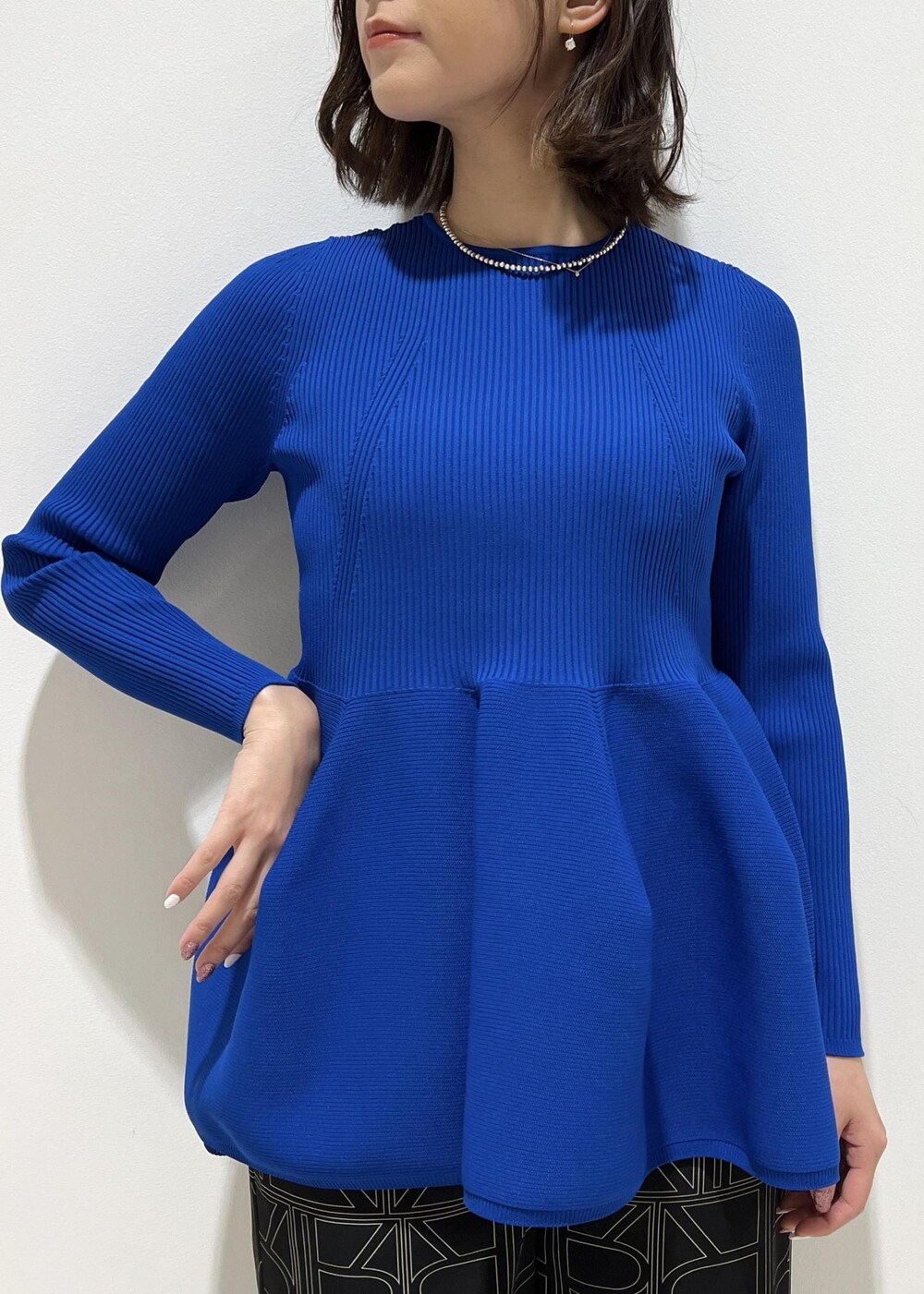 ホワイト系のハンドバッグ、ブラック系のその他パンツ、ブルー系のニット/セーターを着用したレディースの冬コーディネートの5枚目の写真