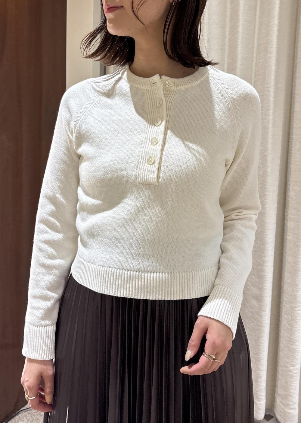 ピンク系のハンドバッグ、ブラウン系のスカート、ホワイト系のニット/セーターを着用したレディースの春コーディネートの5枚目の写真