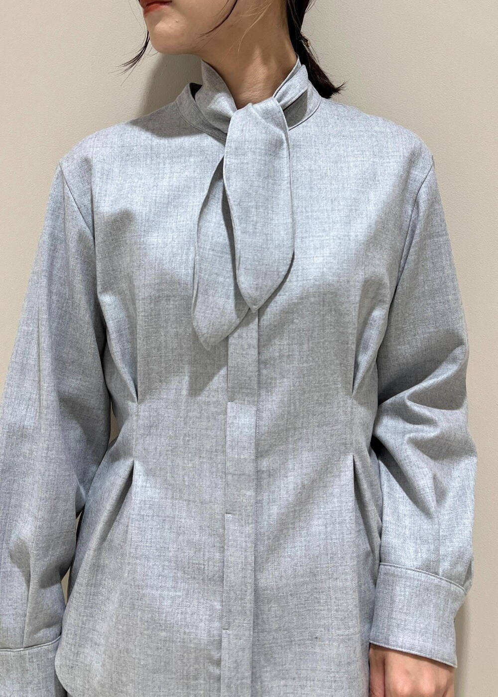 イエロー系のトートバッグ、ブラック系のブーツ、グレー系のシャツ/ブラウスを着用したレディースの秋コーディネートの5枚目の写真