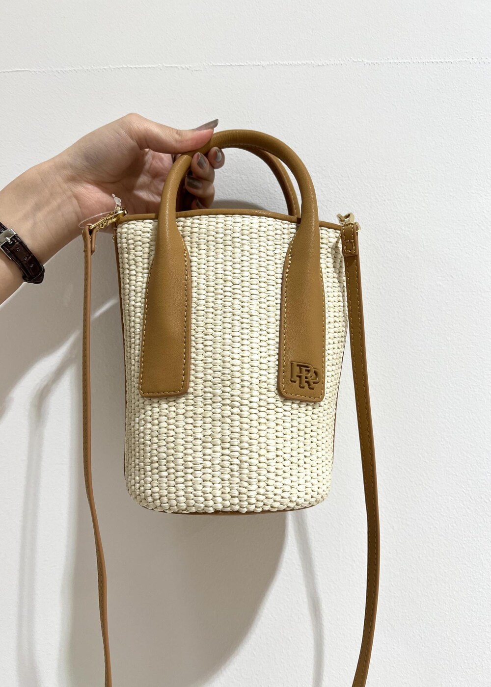 ベージュ系のハンドバッグ、ブラック系のニット/セーター、ベージュ系のスカートを着用したレディースの春コーディネートの8枚目の写真