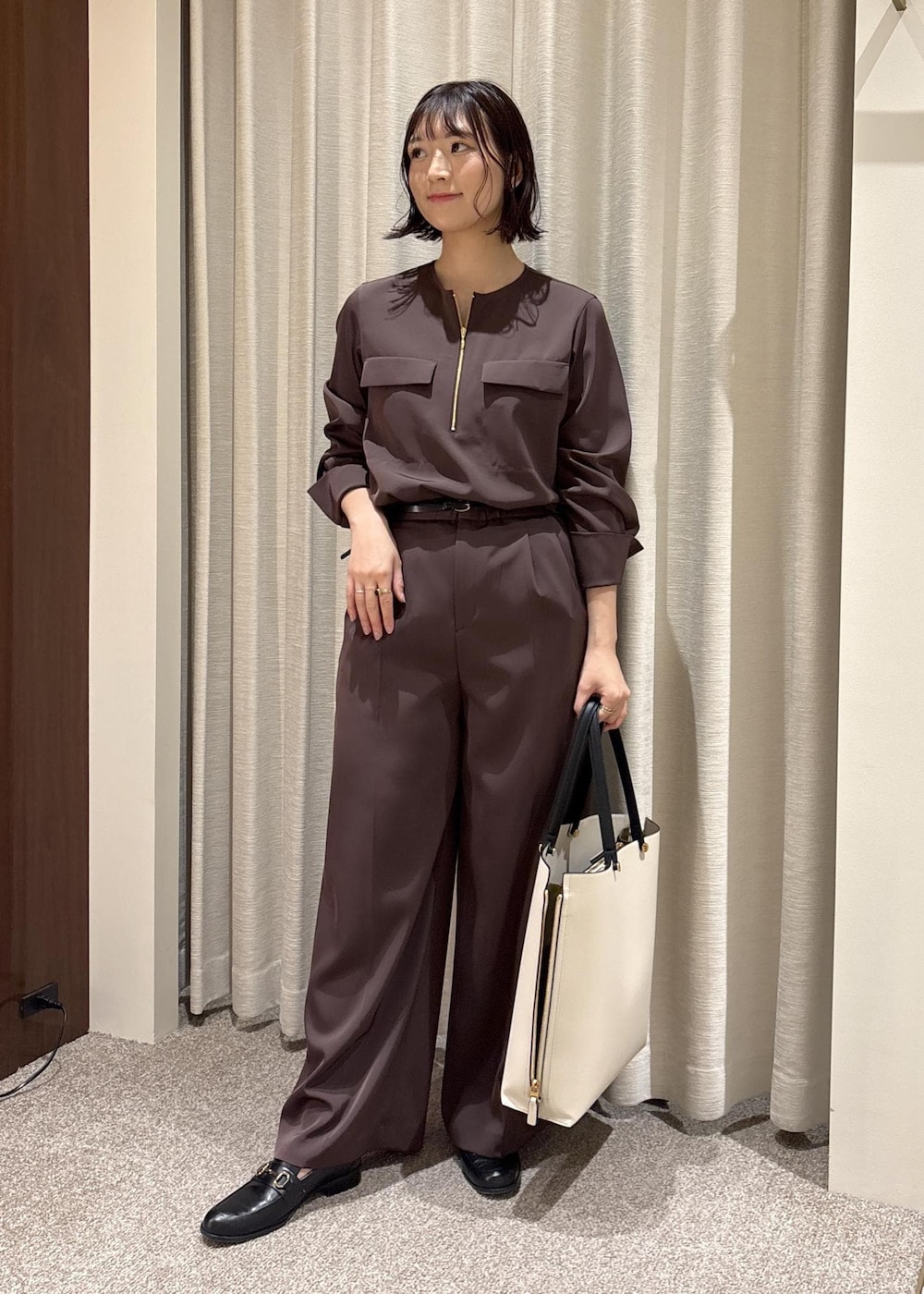 ブラック系のローファー、ホワイト系のトートバッグ、ブラウン系のシャツ/ブラウスを着用したレディースの春コーディネートの2枚目の写真