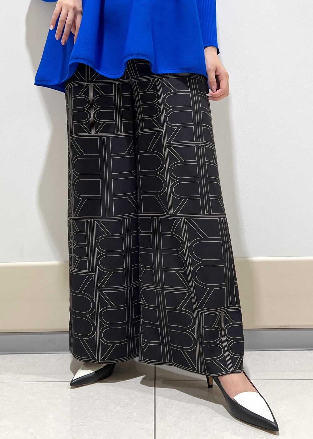 ホワイト系のハンドバッグ、ブラック系のその他パンツ、ブルー系のニット/セーターを着用したレディースの冬コーディネートの6枚目の写真