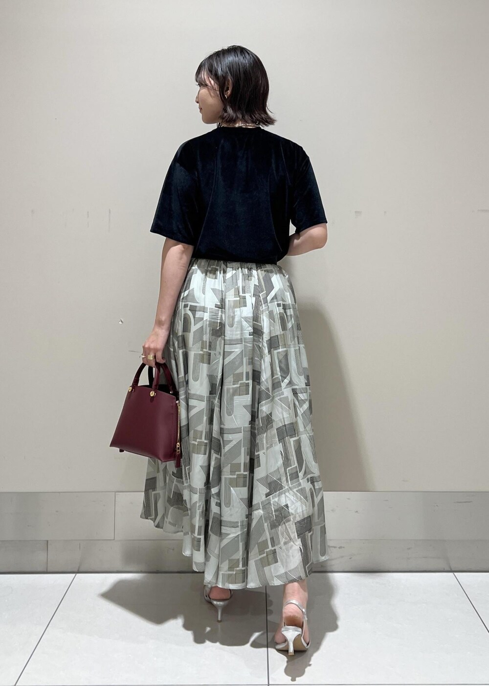 シルバー系のサンダル、レッド系のハンドバッグ、ブラック系のTシャツ/カットソーを着用したレディースの夏コーディネートの5枚目の写真