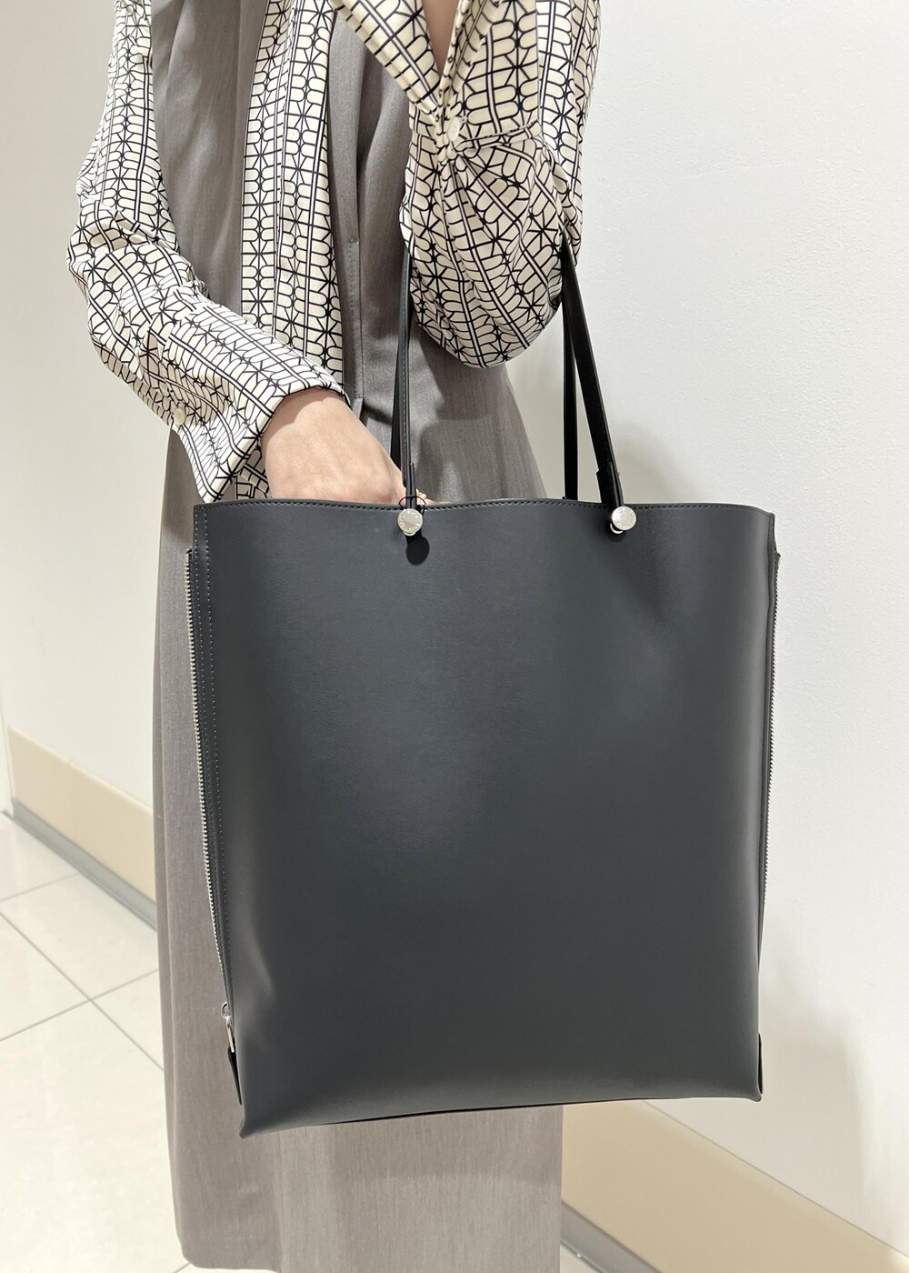 ホワイト系のシャツ/ブラウス、ブルー系のトートバッグ、ブラック系のパンプスを着用したレディースの春コーディネートの9枚目の写真