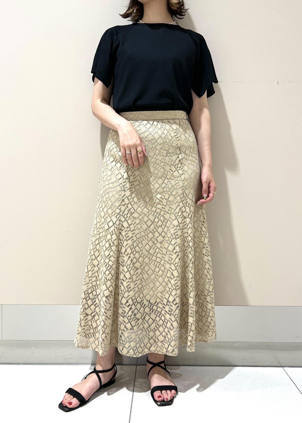 ベージュ系のハンドバッグ、ブラック系のニット/セーター、ベージュ系のスカートを着用したレディースの春コーディネートの4枚目の写真