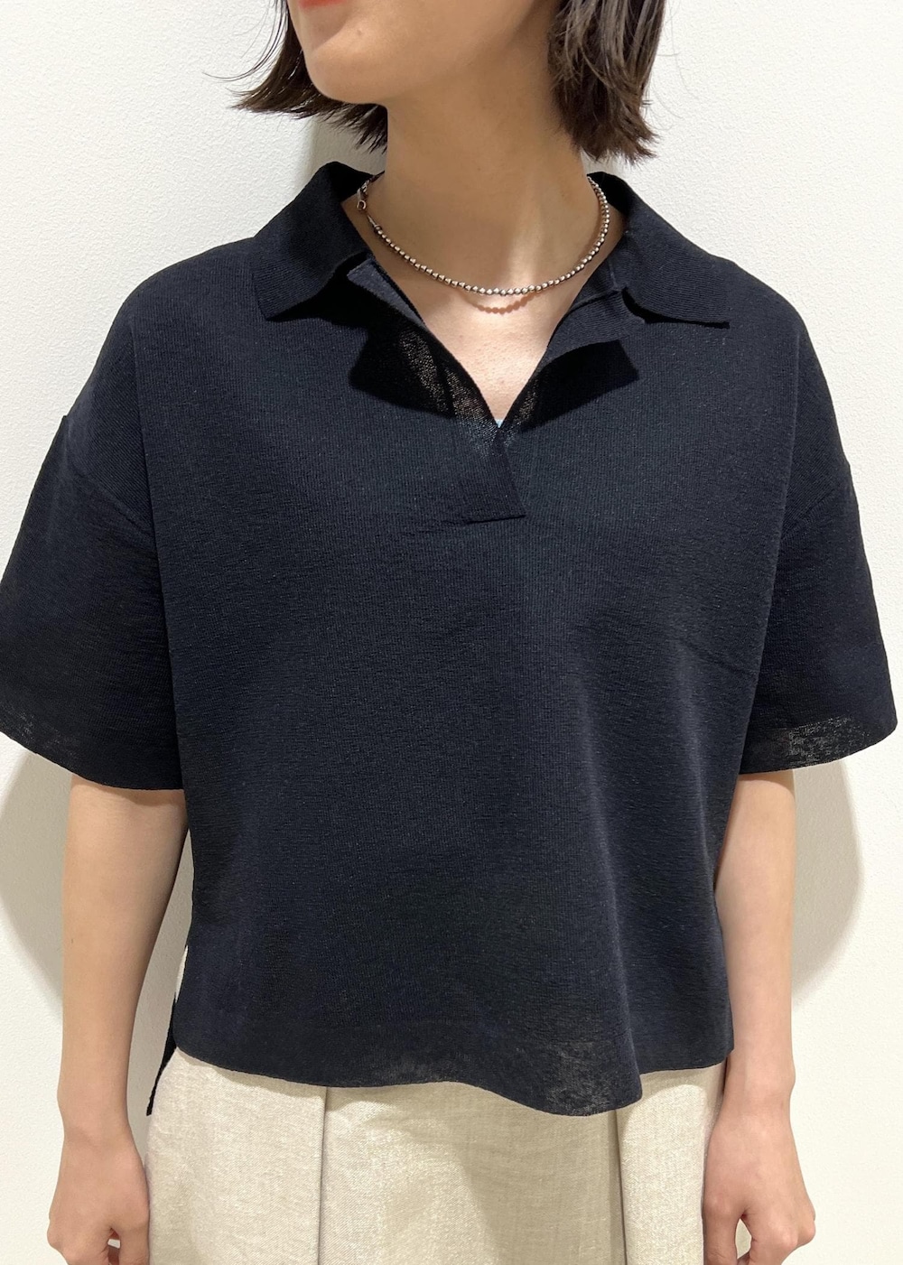 ブラック系のハンドバッグ、シルバー系のパンプス、ブルー系のニット/セーターを着用したレディースの春コーディネートの6枚目の写真