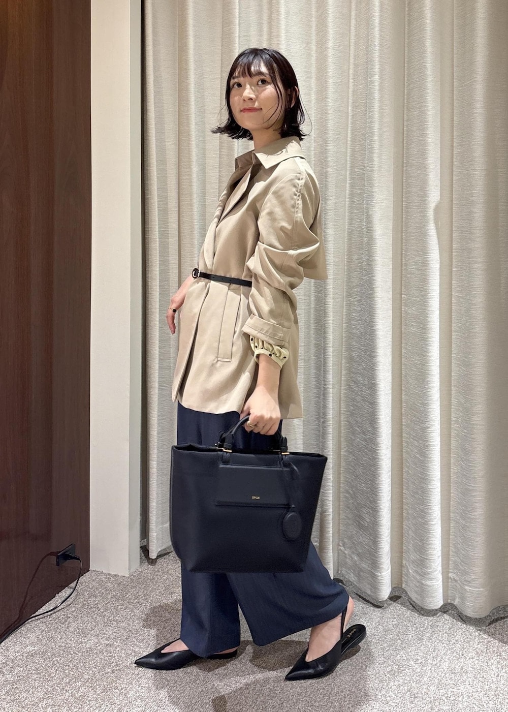 ブラック系のパンプス、ブラック系のトートバッグ、ブルー系のその他パンツを着用したレディースの春コーディネートの3枚目の写真