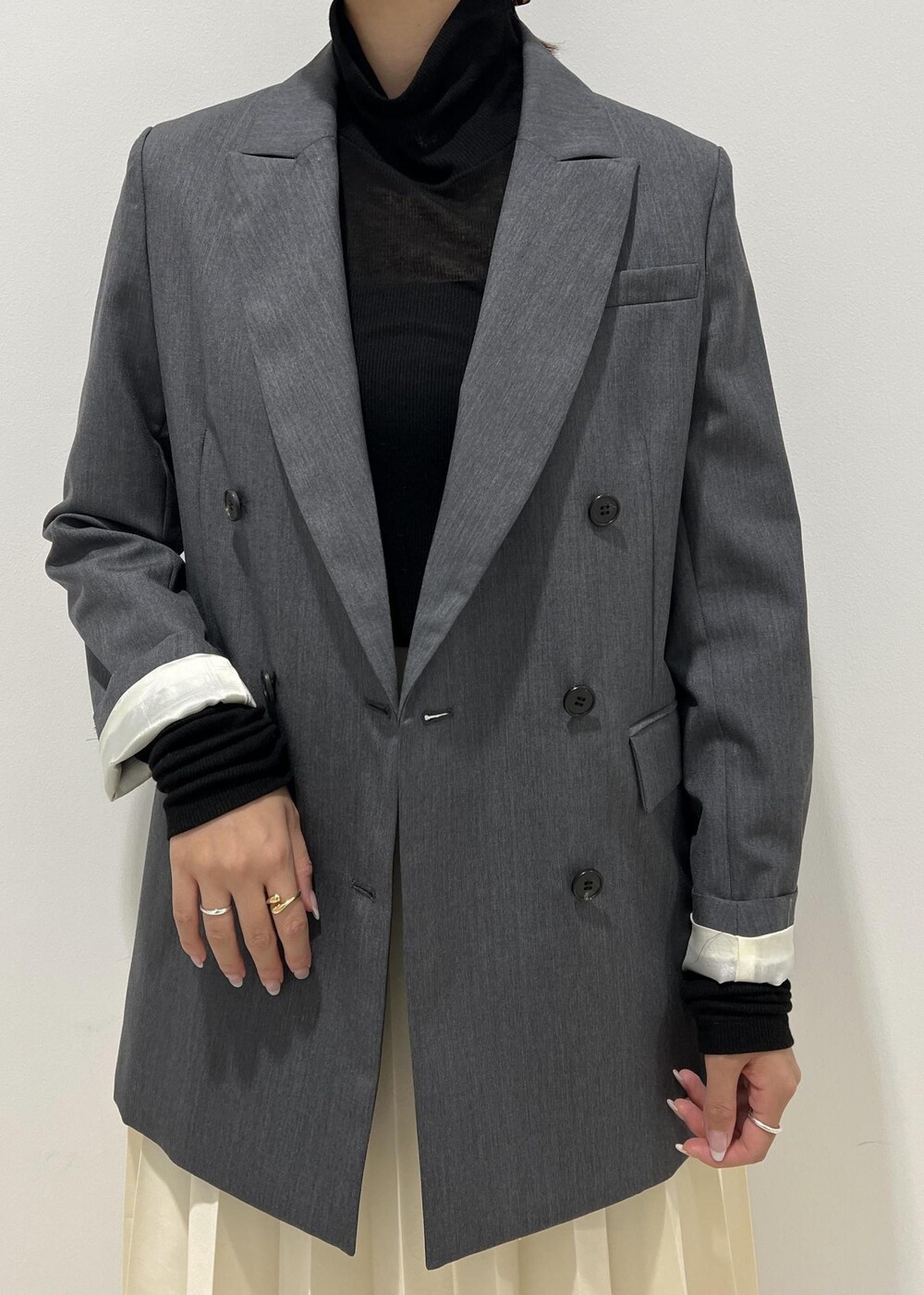 ブラック系のブーツ、ベージュ系のスカート、ブラック系のTシャツ/カットソーを着用したレディースの秋コーディネートの6枚目の写真