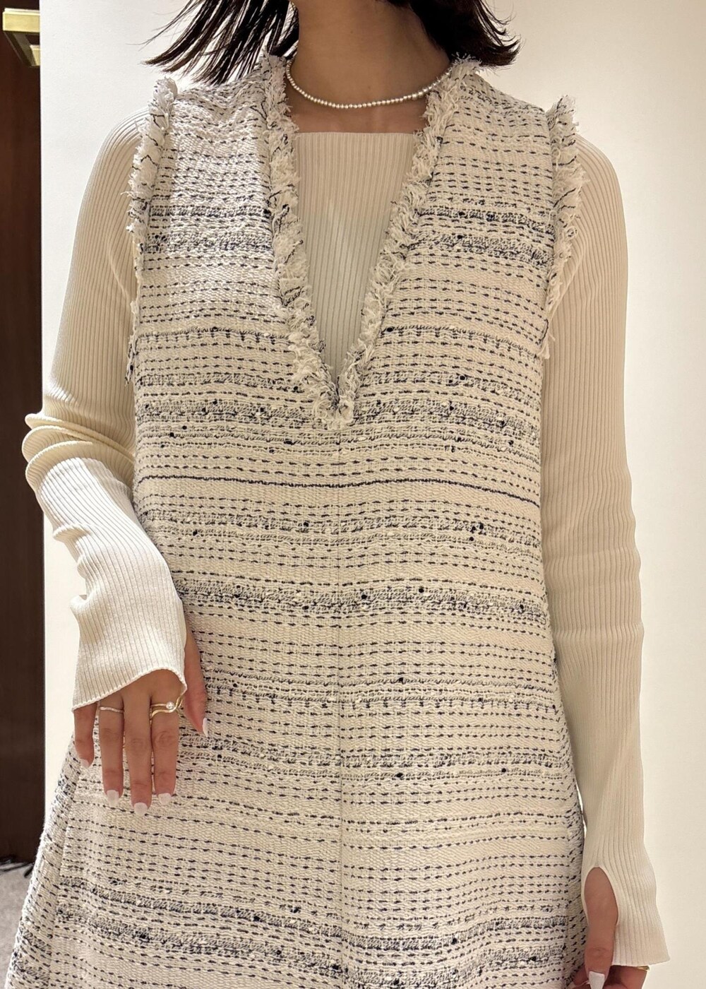 ブラック系のパンプス、ホワイト系のワンピース、ホワイト系のニット/セーターを着用したレディースの春コーディネートの5枚目の写真