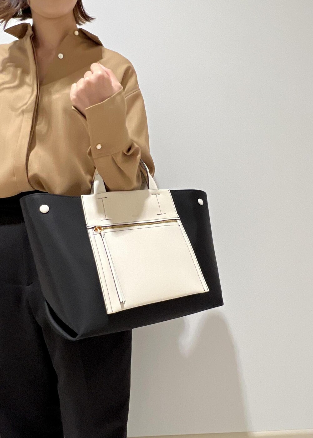 ブラック系のハンドバッグ、ベージュ系のシャツ/ブラウス、ブラック系のその他パンツを着用したレディースの秋コーディネートの7枚目の写真