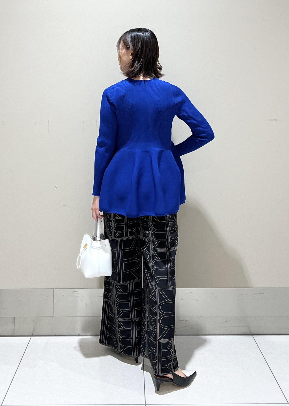 ホワイト系のハンドバッグ、ブラック系のその他パンツ、ブルー系のニット/セーターを着用したレディースの冬コーディネートの4枚目の写真