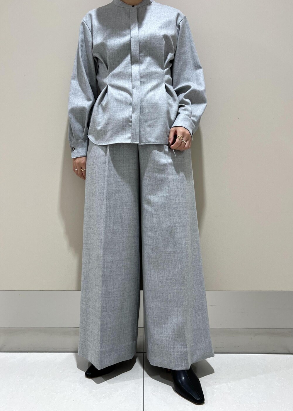 イエロー系のトートバッグ、ブラック系のブーツ、グレー系のシャツ/ブラウスを着用したレディースの秋コーディネートの7枚目の写真