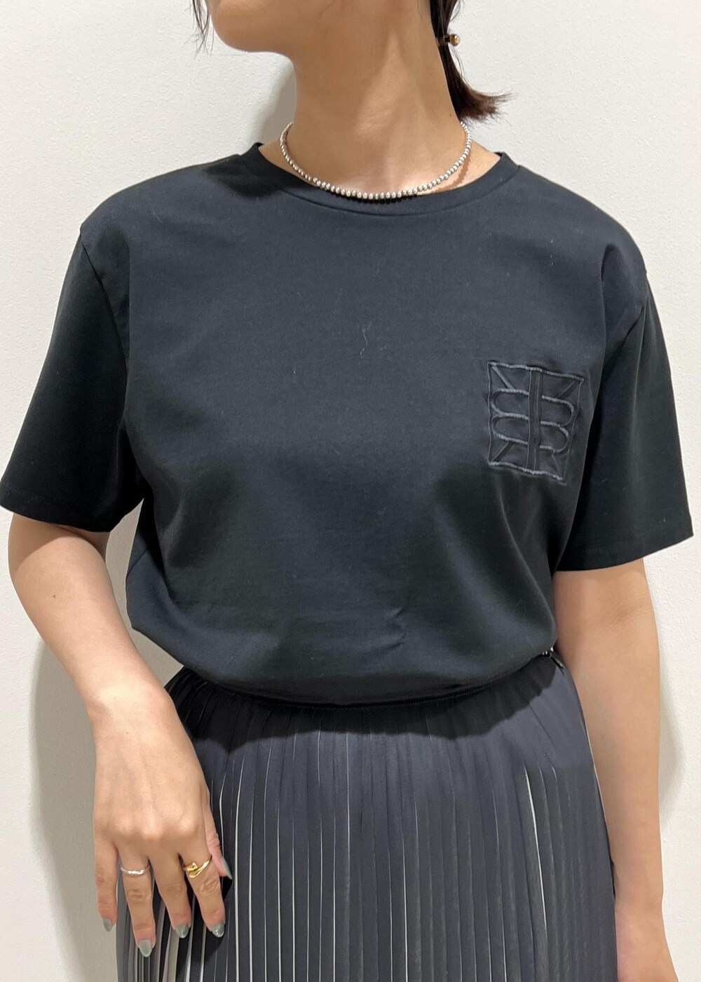 シルバー系のサンダル、グリーン系のショルダーバッグ、ブラック系のスカートを着用したレディースの夏コーディネートの8枚目の写真