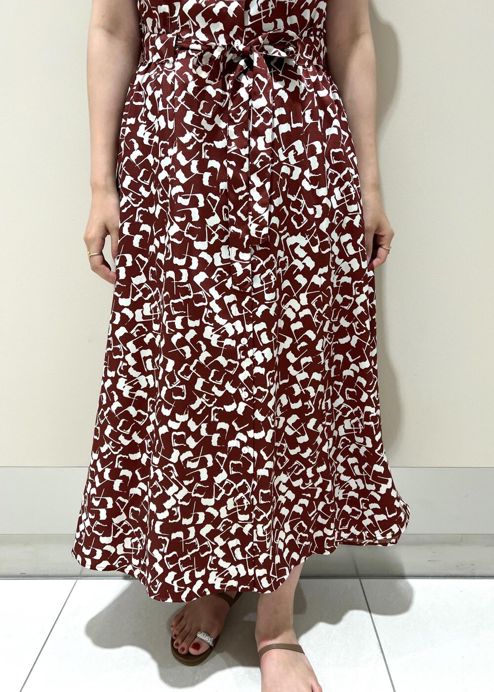 ブラック系のハンドバッグ、ベージュ系のサンダル、レッド系のワンピースを着用したレディースの夏コーディネートの6枚目の写真