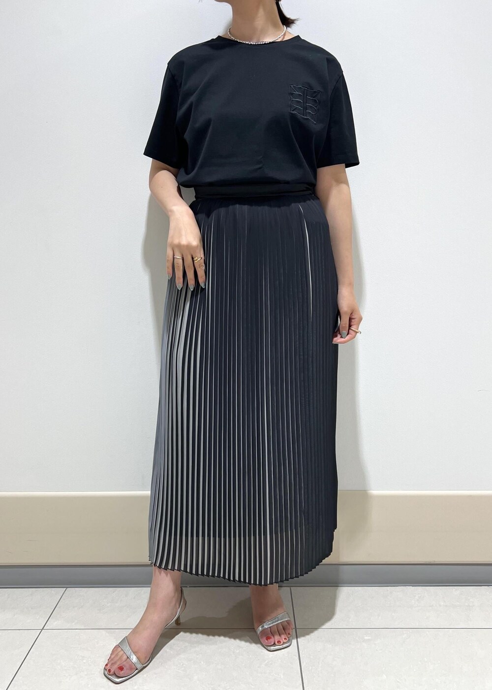 シルバー系のサンダル、グリーン系のショルダーバッグ、ブラック系のスカートを着用したレディースの夏コーディネートの6枚目の写真