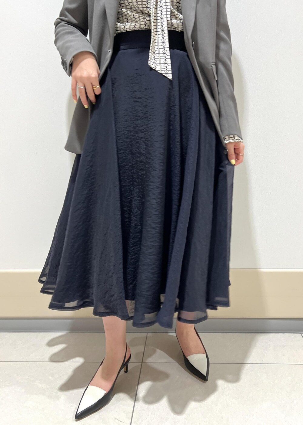ブラック系のパンプス、ブルー系のスカート、ホワイト系のシャツ/ブラウスを着用したレディースの春コーディネートの8枚目の写真