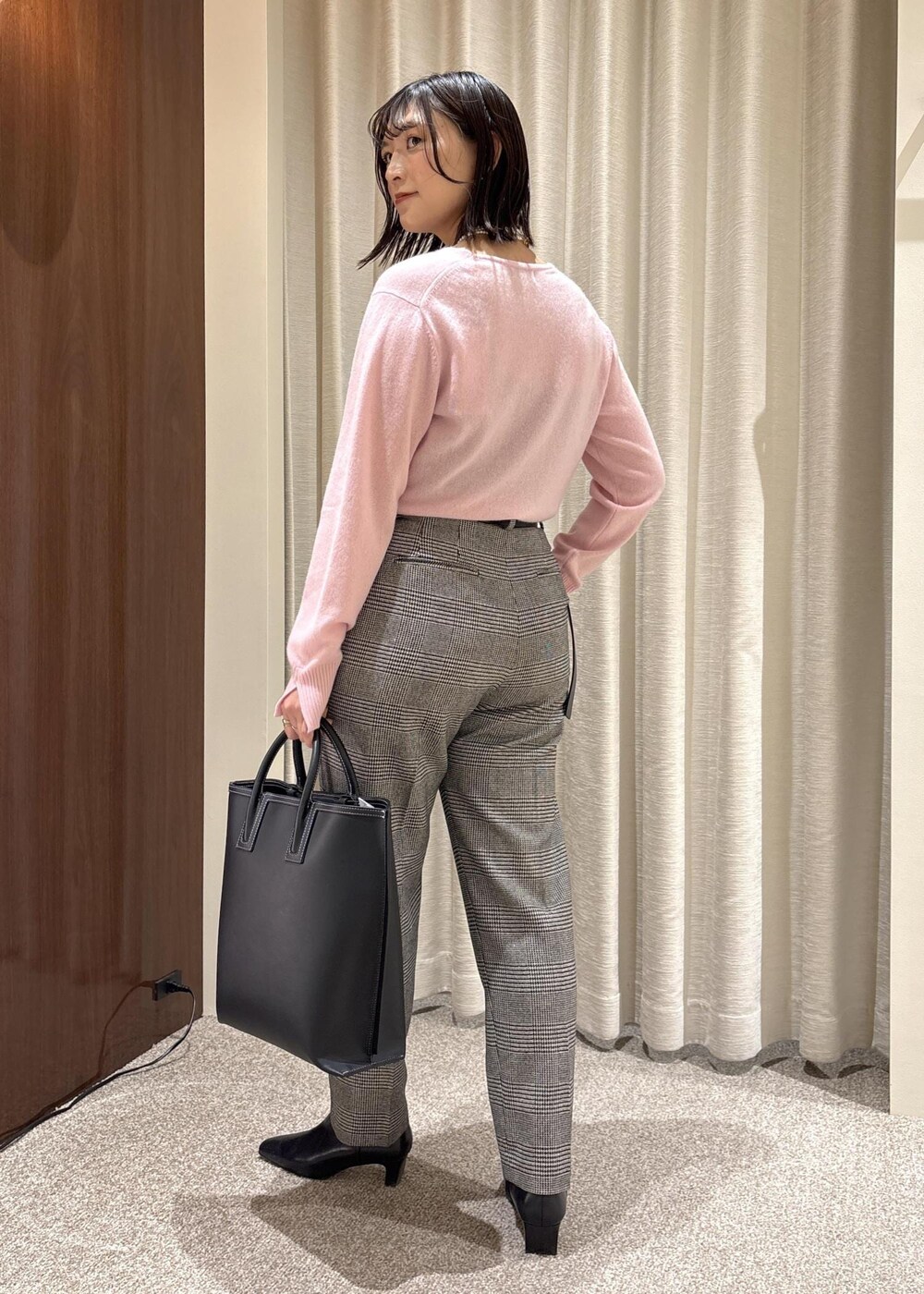 ブラック系のトートバッグ、ブラック系のブーツ、ピンク系のニット/セーターを着用したレディースの秋コーディネートの4枚目の写真