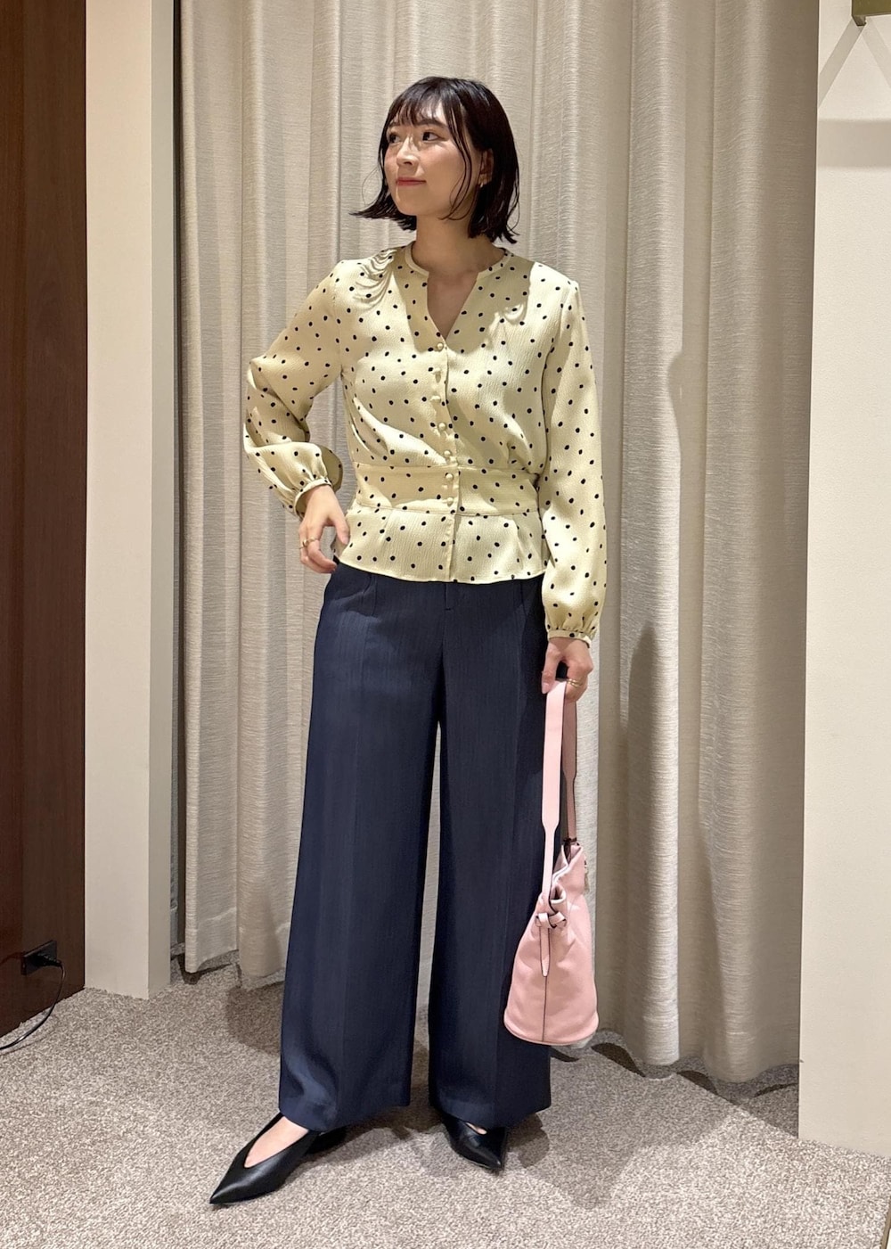 ブラック系のパンプス、ピンク系のハンドバッグ、ブルー系のその他パンツを着用したレディースの春コーディネートの3枚目の写真