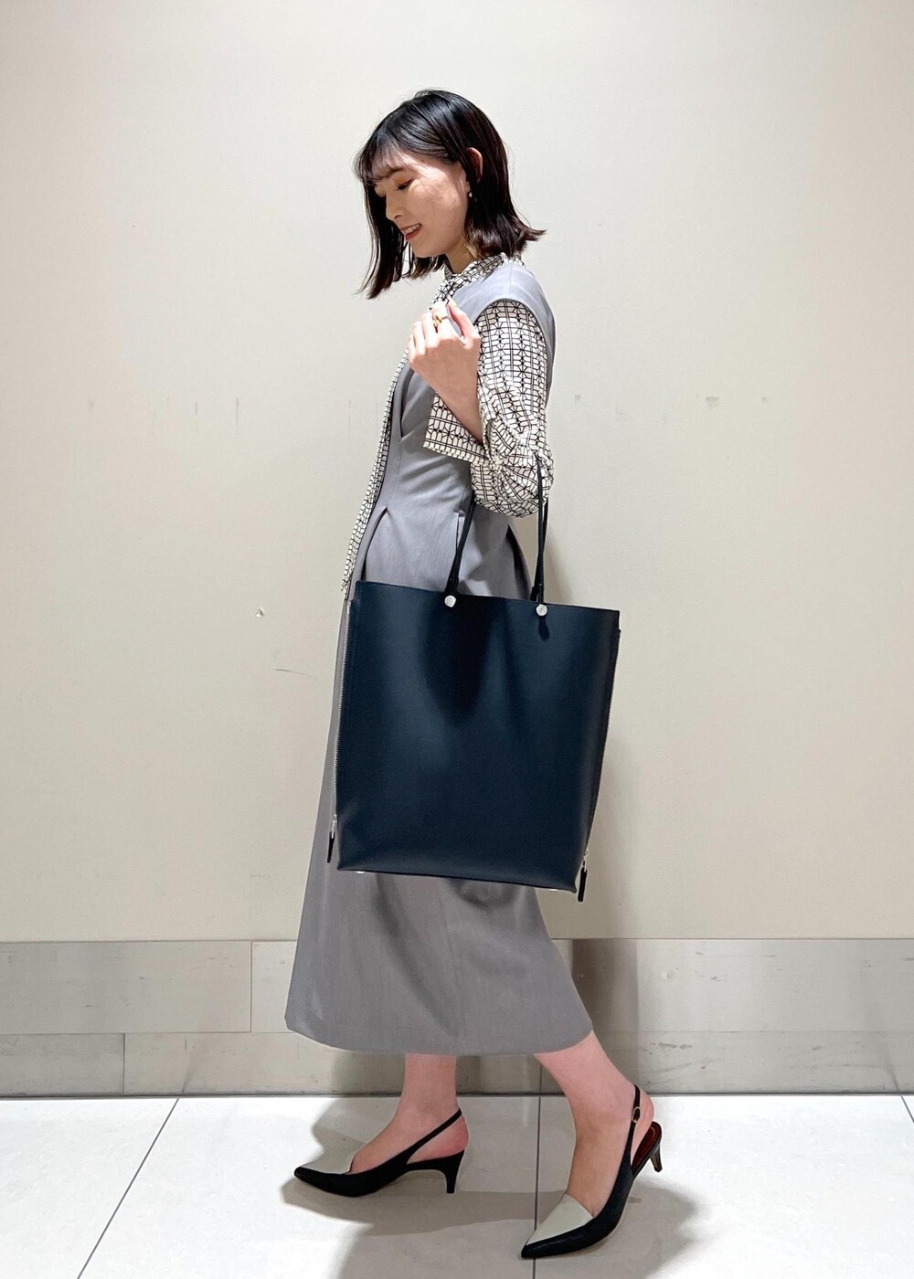 ホワイト系のシャツ/ブラウス、ブルー系のトートバッグ、ブラック系のパンプスを着用したレディースの春コーディネートの4枚目の写真