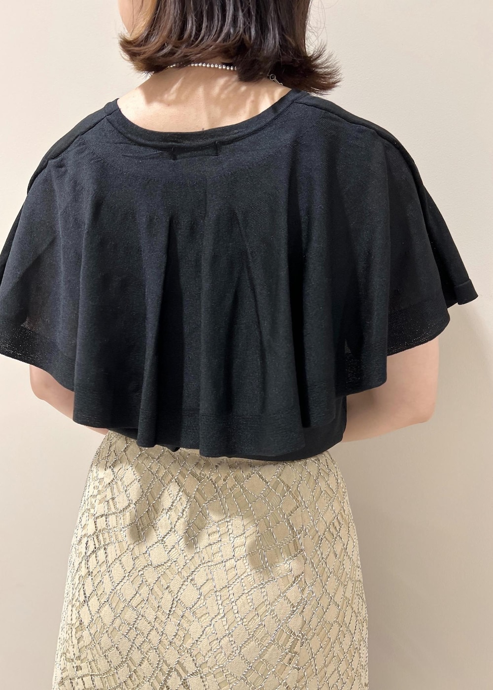 ベージュ系のハンドバッグ、ブラック系のニット/セーター、ベージュ系のスカートを着用したレディースの春コーディネートの7枚目の写真