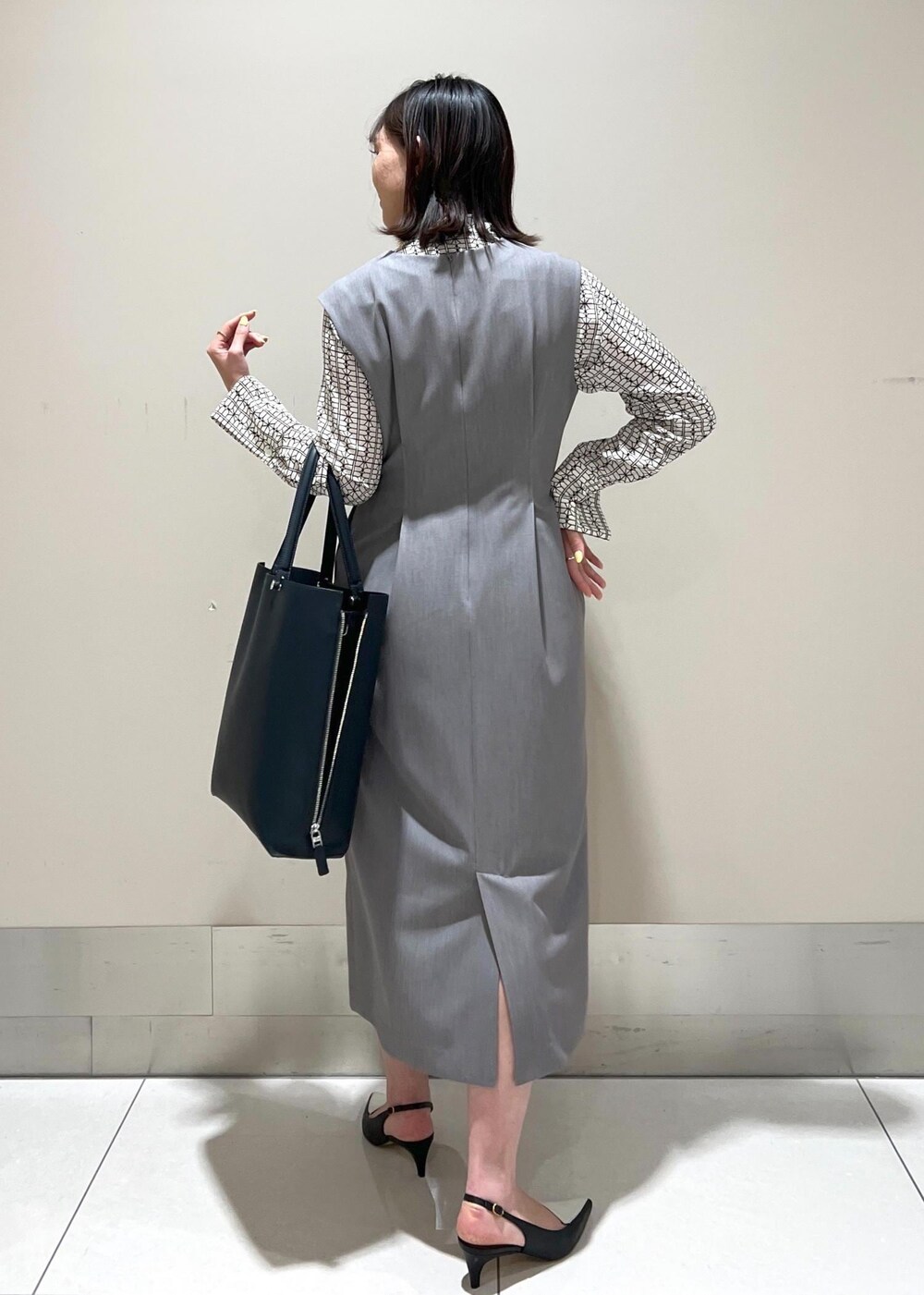 ホワイト系のシャツ/ブラウス、ブルー系のトートバッグ、ブラック系のパンプスを着用したレディースの春コーディネートの5枚目の写真