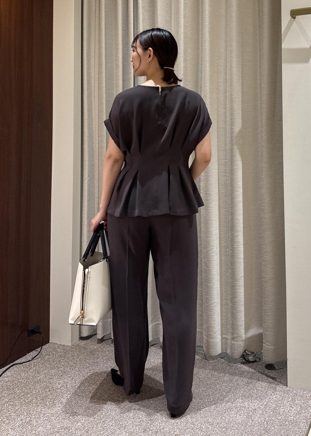 ブラック系のパンプス、ホワイト系のトートバッグ、ブラウン系のシャツ/ブラウスを着用したレディースの夏コーディネートの4枚目の写真