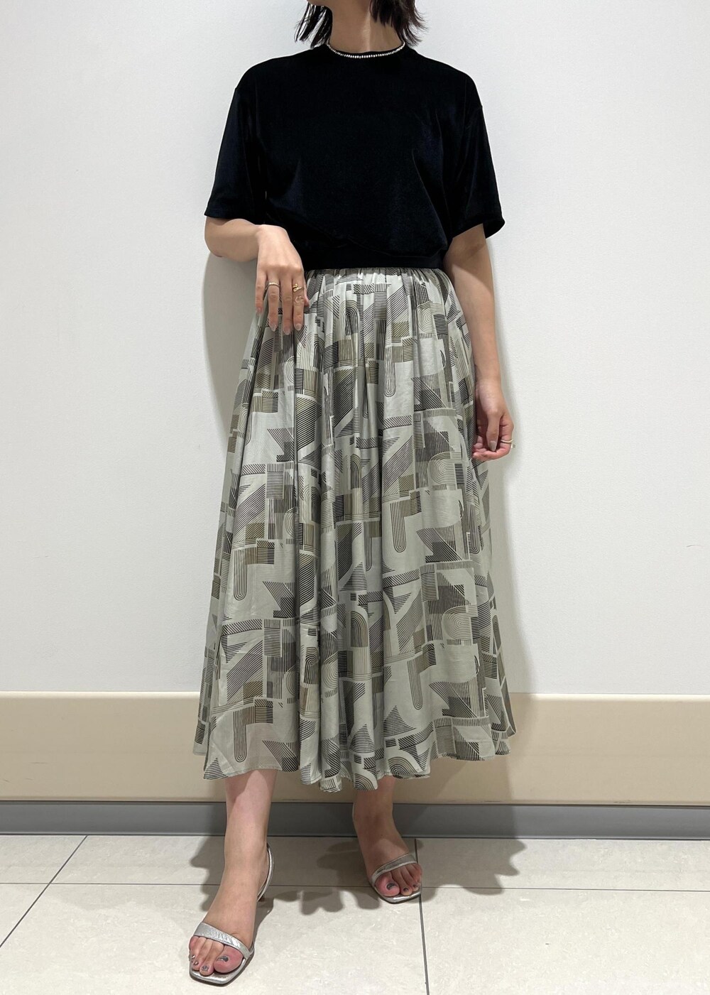 シルバー系のサンダル、レッド系のハンドバッグ、ブラック系のTシャツ/カットソーを着用したレディースの夏コーディネートの6枚目の写真