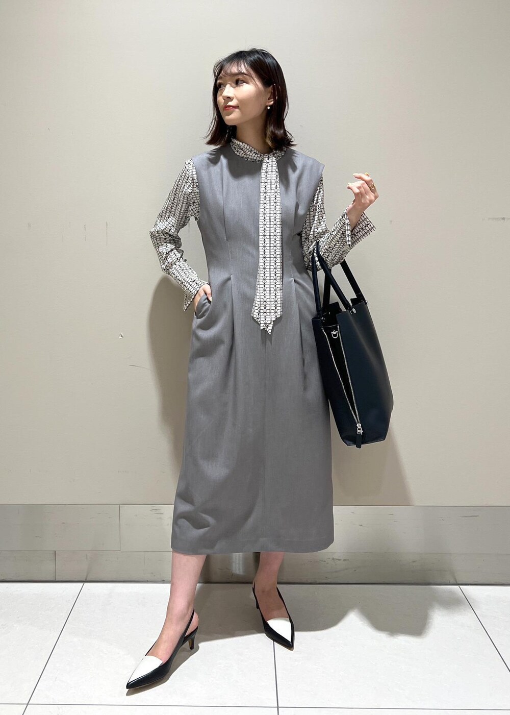 ホワイト系のシャツ/ブラウス、ブルー系のトートバッグ、ブラック系のパンプスを着用したレディースの春コーディネートの3枚目の写真