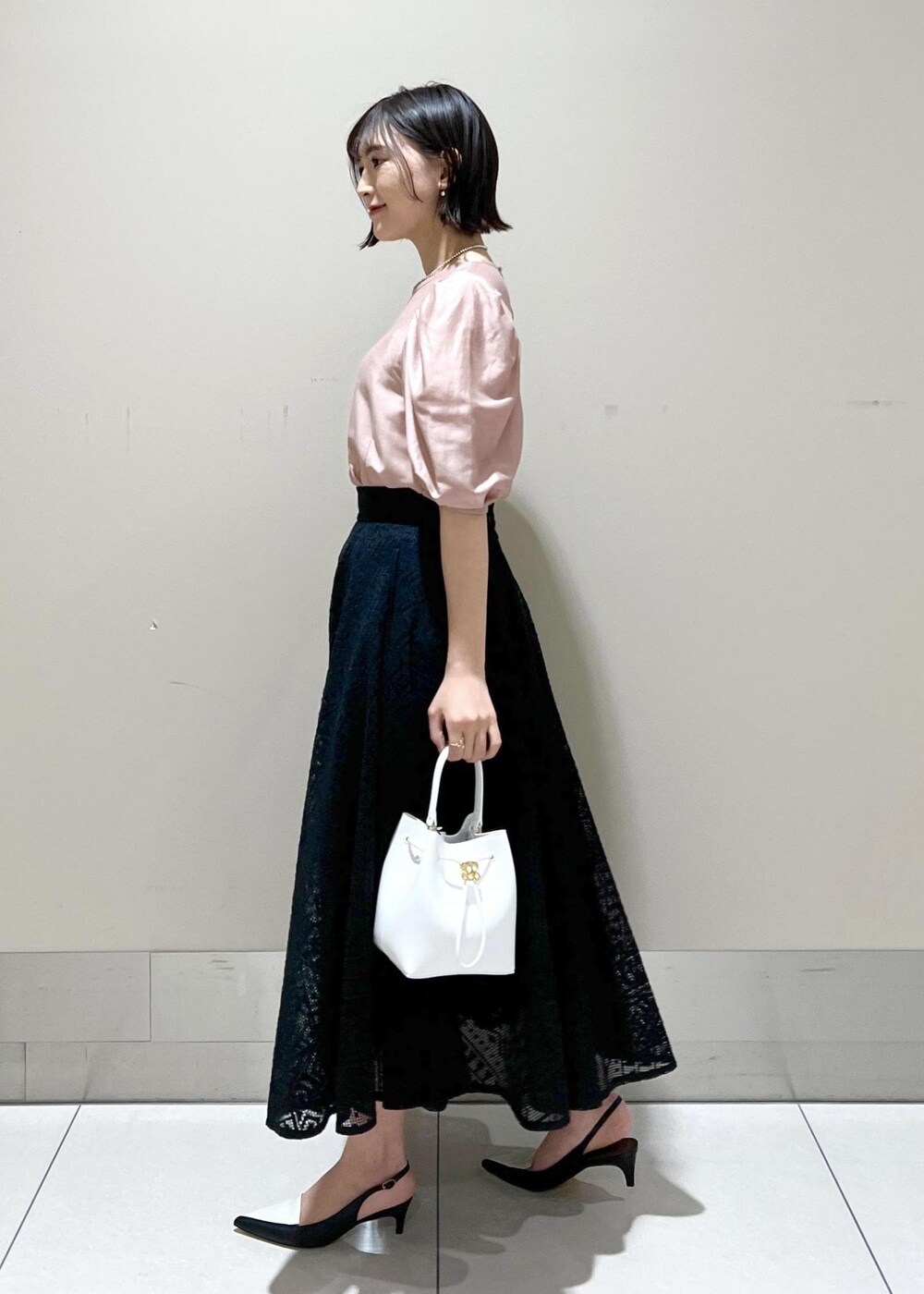ホワイト系のハンドバッグ、ブラック系のパンプス、ピンク系のシャツ/ブラウスを着用したレディースの春コーディネートの4枚目の写真