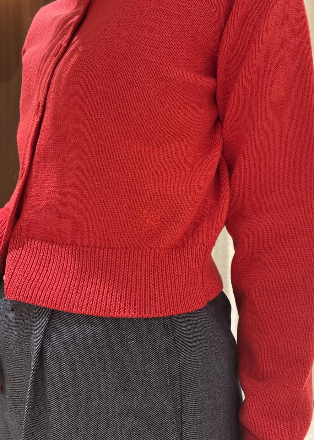 ベージュ系のトートバッグ、ブルー系のスラックス、レッド系のカーディガン/ボレロを着用したレディースの冬コーディネートの7枚目の写真