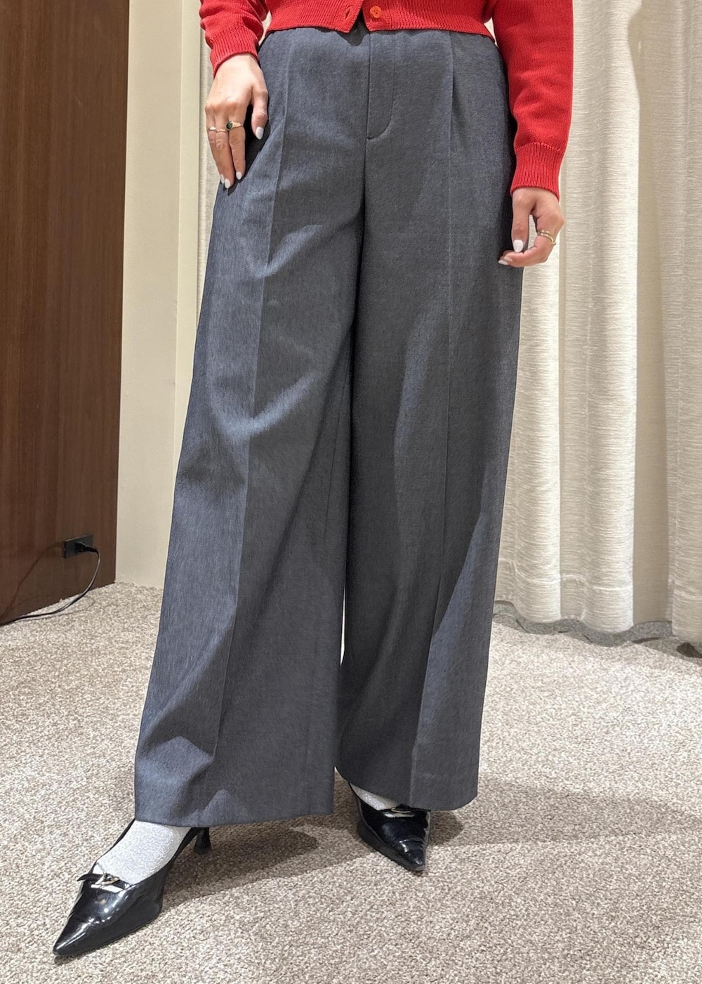 ベージュ系のトートバッグ、ブルー系のスラックス、レッド系のカーディガン/ボレロを着用したレディースの冬コーディネートの9枚目の写真