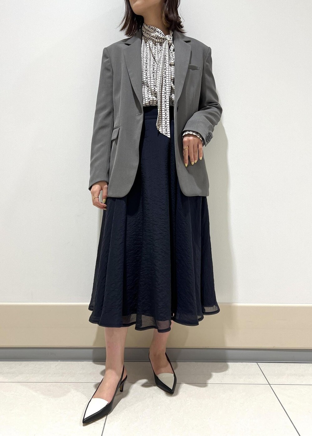 ブラック系のパンプス、ブルー系のスカート、ホワイト系のシャツ/ブラウスを着用したレディースの春コーディネートの5枚目の写真