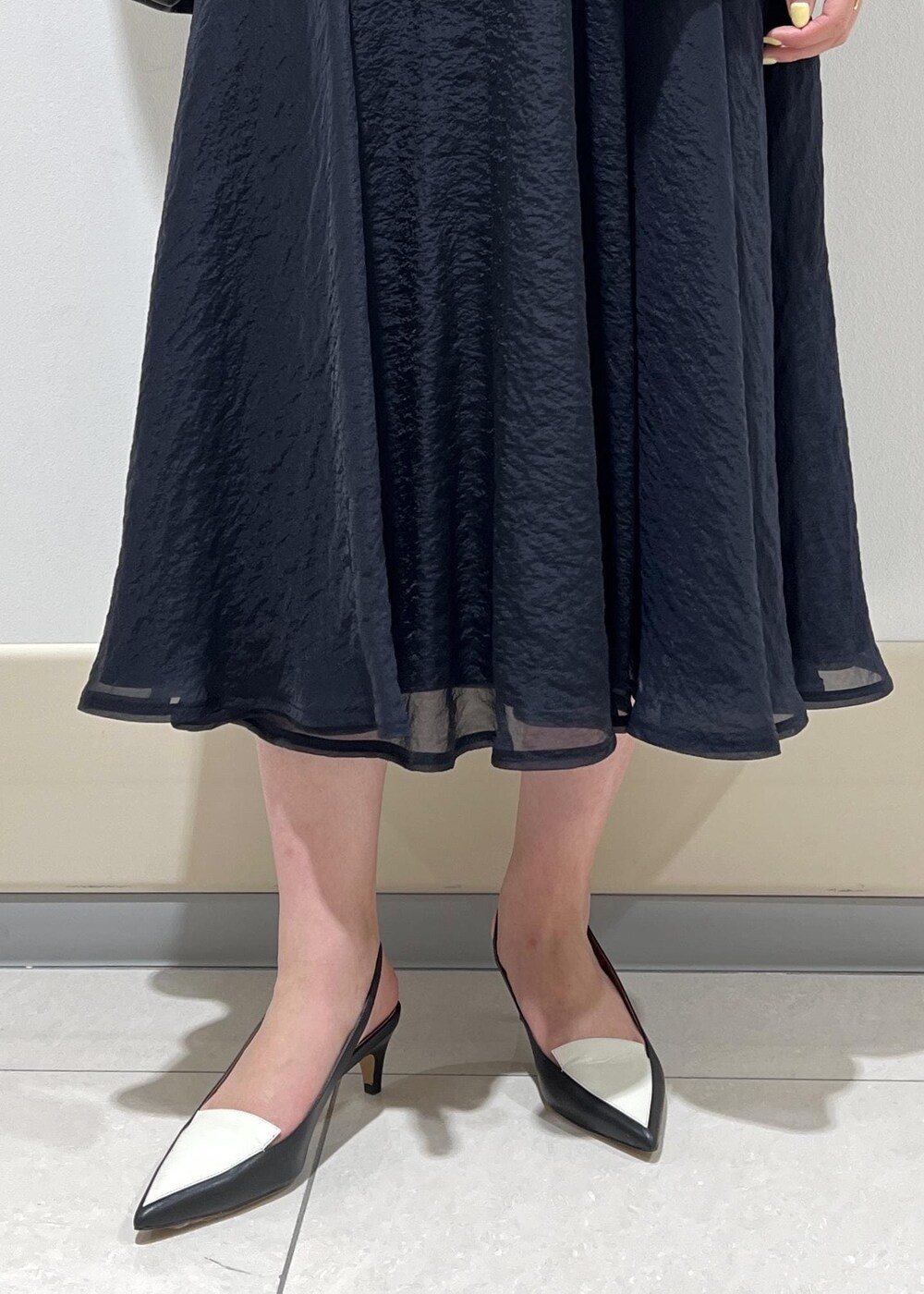 ブラック系のパンプス、ブルー系のスカート、ホワイト系のシャツ/ブラウスを着用したレディースの春コーディネートの9枚目の写真