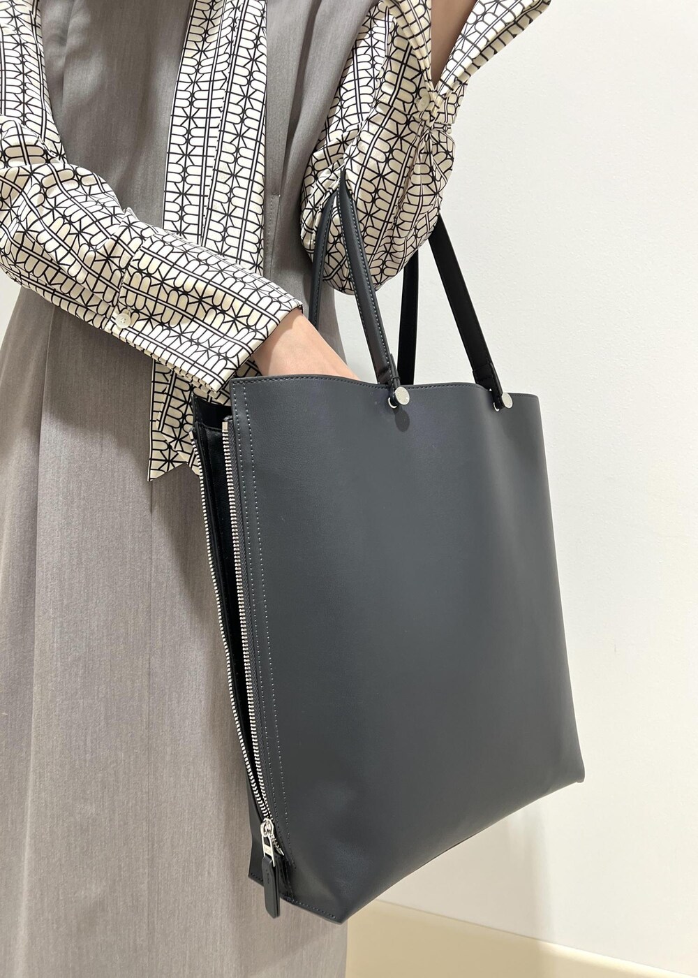 ホワイト系のシャツ/ブラウス、ブルー系のトートバッグ、ブラック系のパンプスを着用したレディースの春コーディネートの10枚目の写真