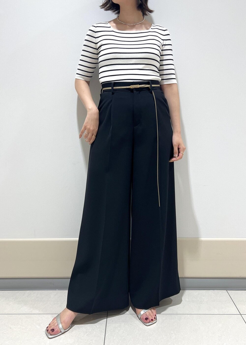 シルバー系のサンダル、ホワイト系のTシャツ/カットソー、ベージュ系のハンドバッグを着用したレディースの春コーディネートの5枚目の写真