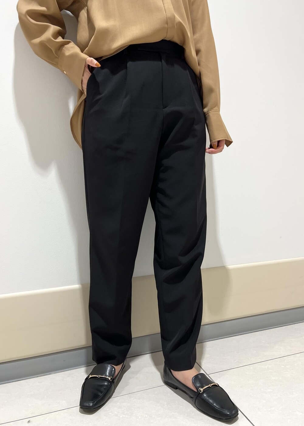 ブラック系のハンドバッグ、ベージュ系のシャツ/ブラウス、ブラック系のその他パンツを着用したレディースの秋コーディネートの6枚目の写真