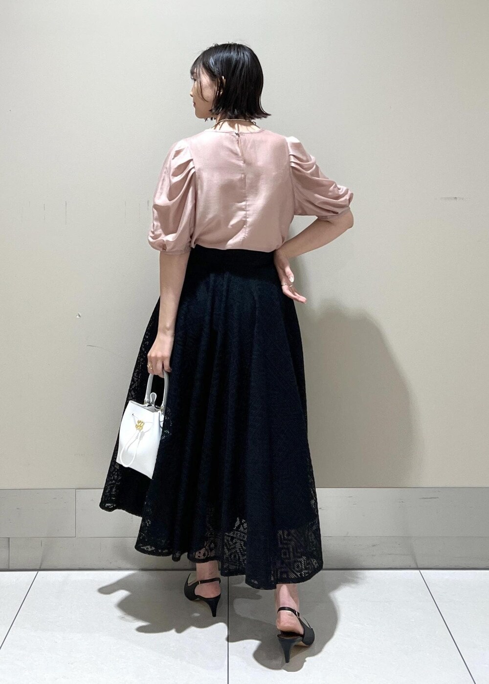 ホワイト系のハンドバッグ、ブラック系のパンプス、ピンク系のシャツ/ブラウスを着用したレディースの春コーディネートの5枚目の写真