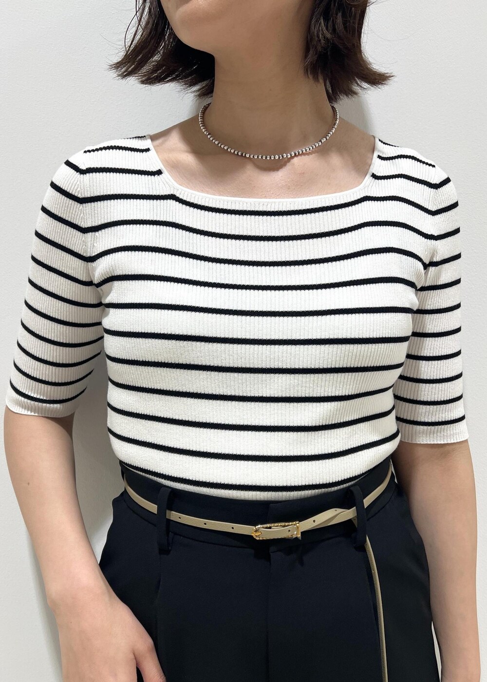 シルバー系のサンダル、ホワイト系のTシャツ/カットソー、ベージュ系のハンドバッグを着用したレディースの春コーディネートの6枚目の写真