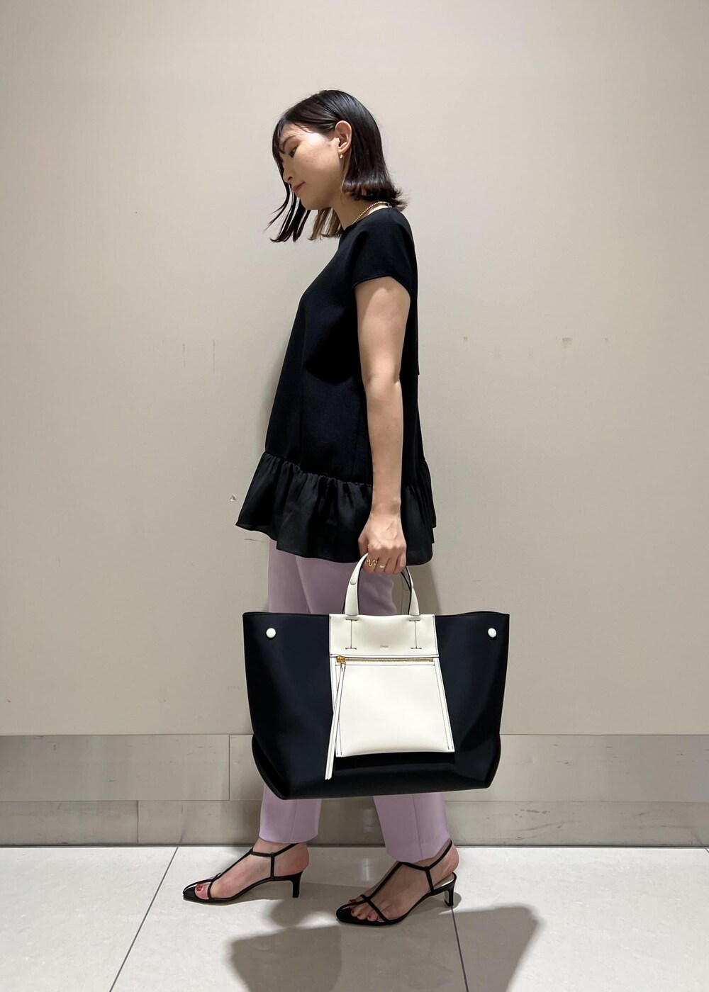 ブラック系のハンドバッグ、パープル系のその他パンツ、ブラック系のサンダルを着用したレディースの夏コーディネートの2枚目の写真