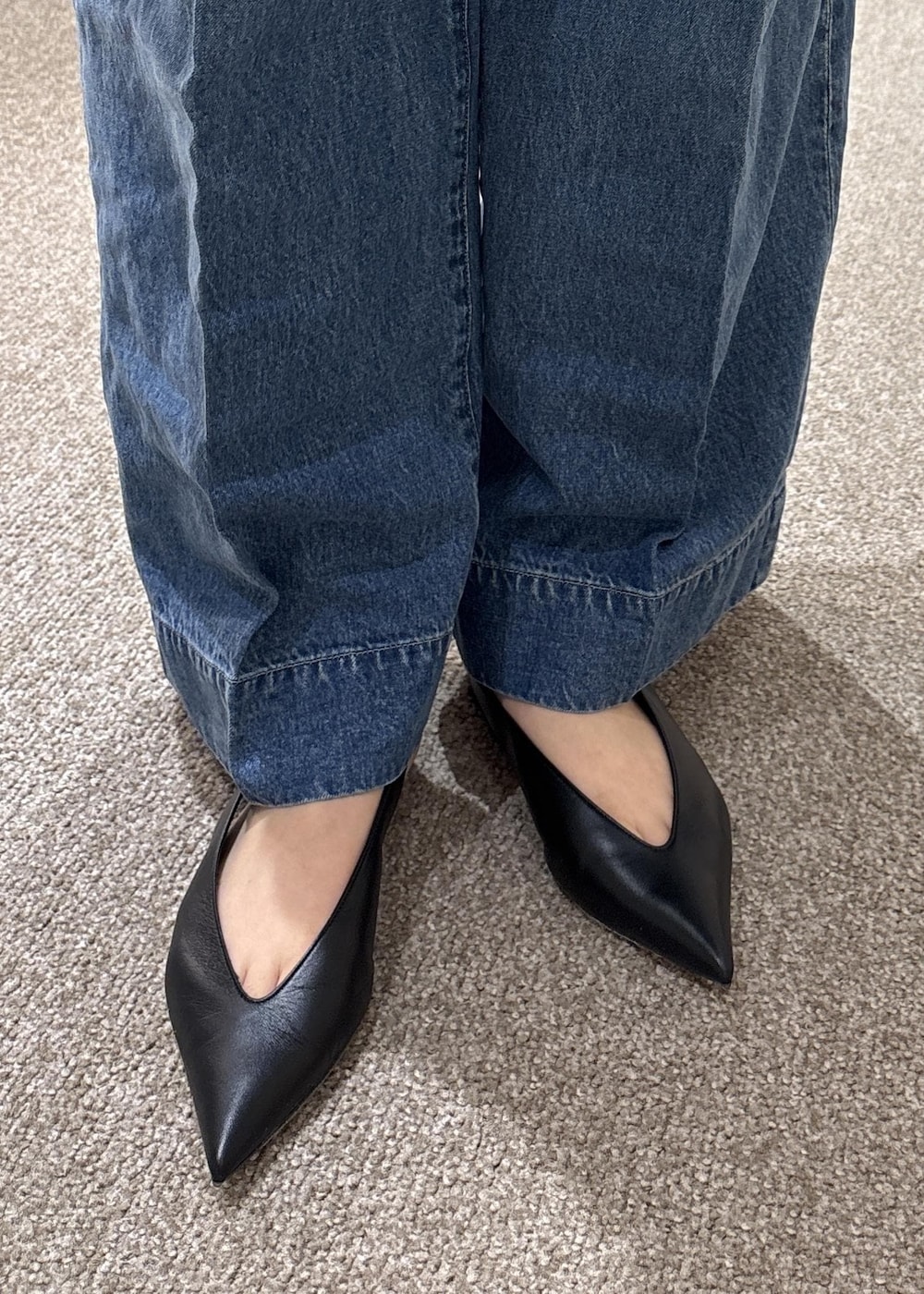 ブラック系のパンプス、ブラック系のハンドバッグ、ブルー系のデニムパンツを着用したレディースの夏コーディネートの7枚目の写真